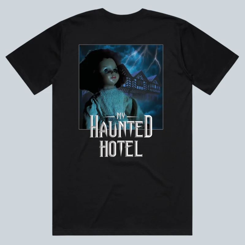 a back of a black shirt displaying the famous Doll from room 5 at My Haunted Hotel